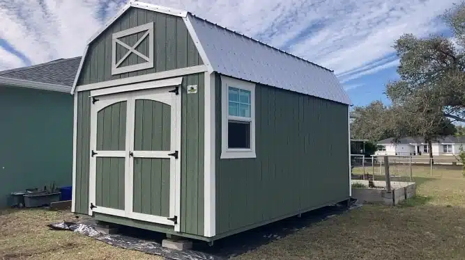 a green 14x24 barn shed with white trim and a metal roof for sale in florida