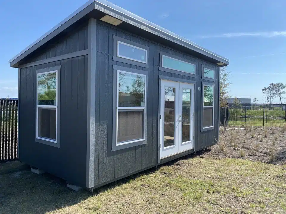 a grey 14x24 studio shed with white trim for sale in florida