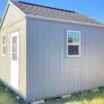 lofted gable shed in the backyard next to a house