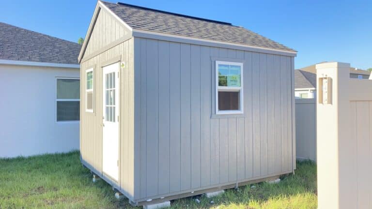 lofted gable shed in the backyard next to a house