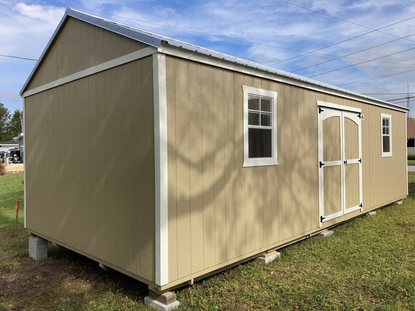 side gable shed with two windows, double doors, and white trim