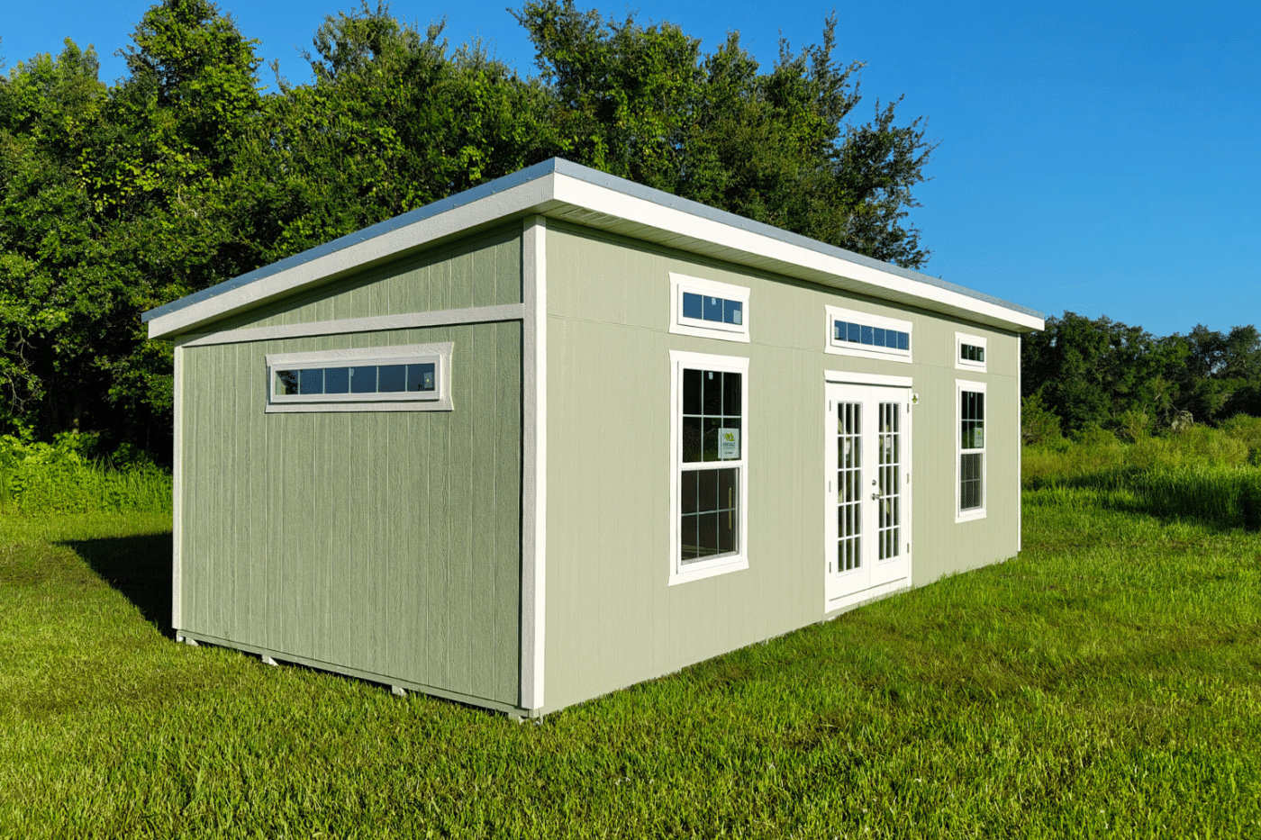 green studio shed with windows and double doors in florida