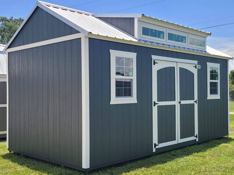 a grey shed with a dormer with transom windows in belle glade fl