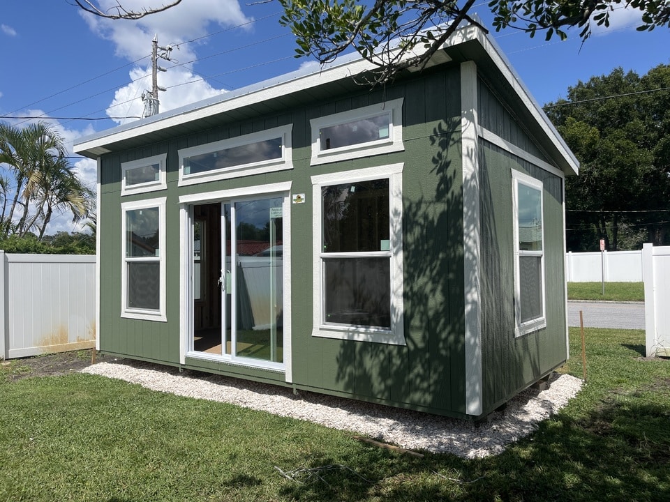 a green studio shed with white trim in clermont fl