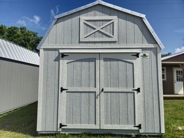 a completely white barn shed standing in the grass next to other barn sheds in montura fl