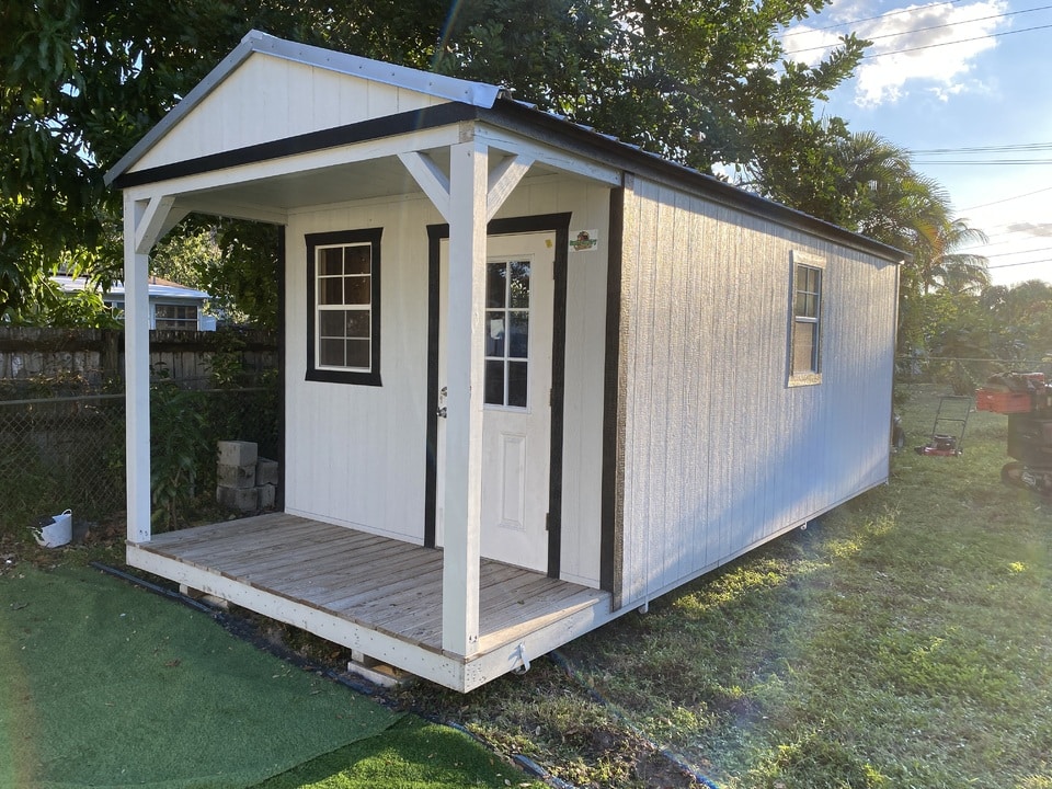 a white cabin shed with black trim in clermont fl