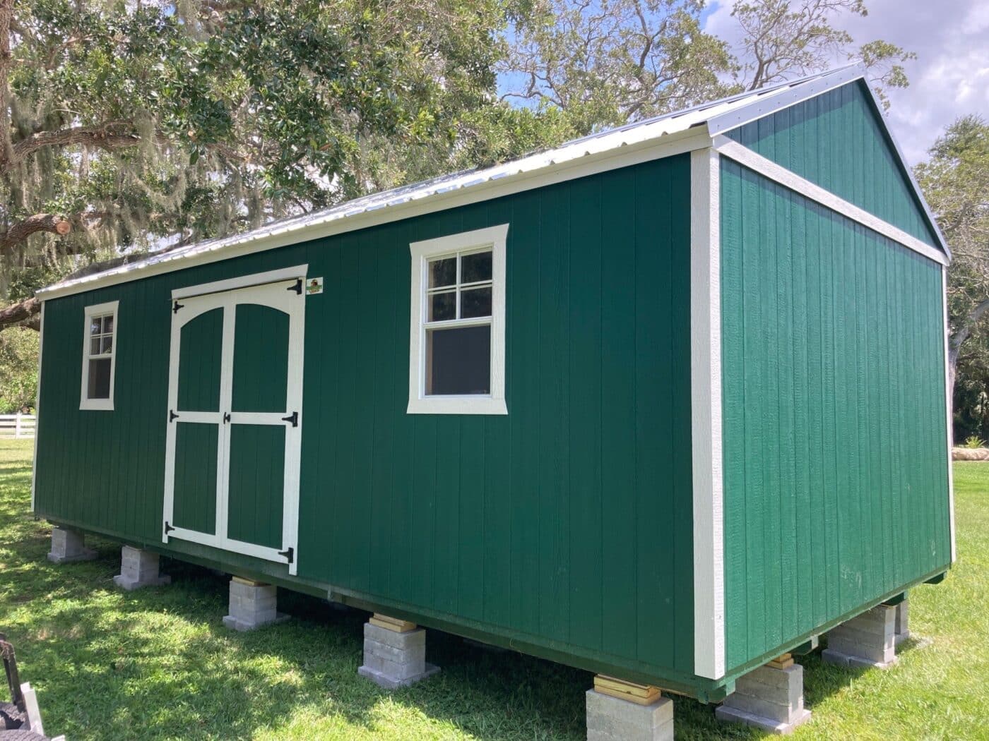 shed with green siding and white trim